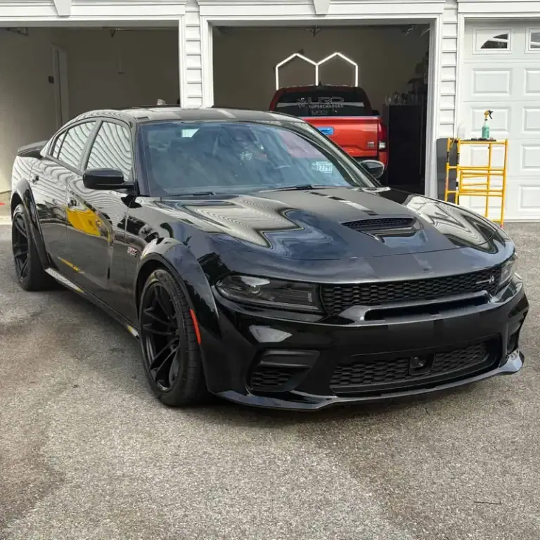 Black car parked outside a garage